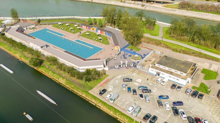 A birds eye visual concept of Hilsea Lido, showing the pool, beach hut changing rooms, sun loungers and a car park